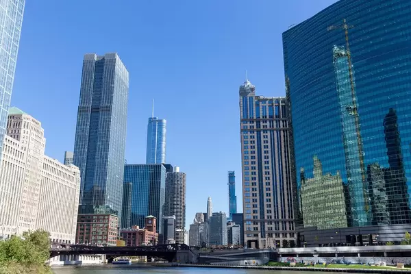 Die gekrümmten Glasfassade des Nuveen Gebäudes am Chicago River mit Spiegelung von anderen Wolkenkratzern
