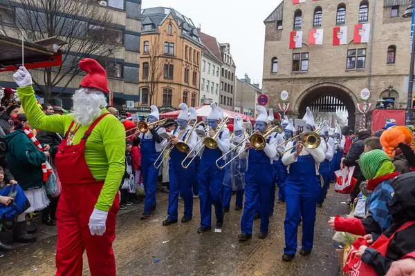 Die Musiker vom Musikverein Merazhofen aus Allgäu spielen als Schlümpfe verkleidet beim Rosenmontagszug in Köln. Ihr Dirigent marschiert als Papa Schlumpf verkleidet und leitet die Gruppe an
