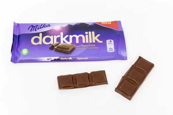 Die neue Milka - Schokolade "darkmilk" aus Aplenmilch mit lila Verpackung auf weißem Untergrund