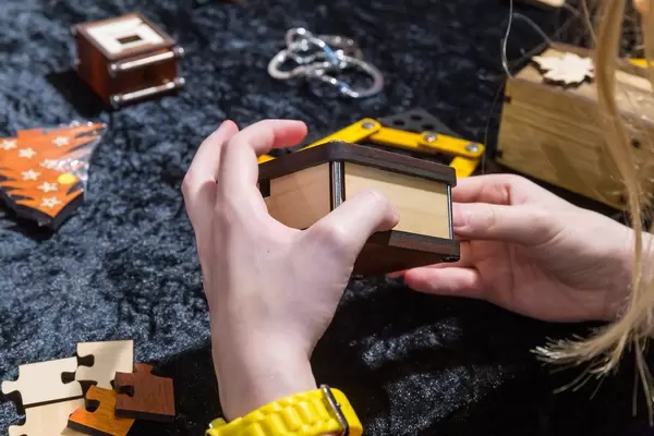 Die Rätsel Manufaktur eine Frau hält eine Truhe in den Händen