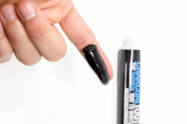 Die schwarze Kokosnuss-Aktivkohle-Zahnpasta zur Anschau auf dem Finger