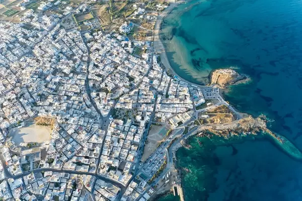 Die Stadt Naxos oder Chora mit weißen Gebäuden und dem Agios Georgios Strand. Luftaufnahme