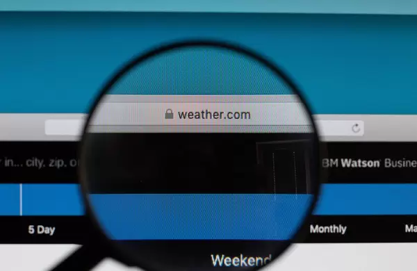 Die URL der Wetterseite "weather.com", vergrößert dargestellt durch ein Lupenglas