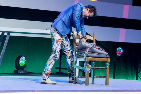 Diemtar Dahmen cutting a pillow at a stage show at Digital X in Cologne