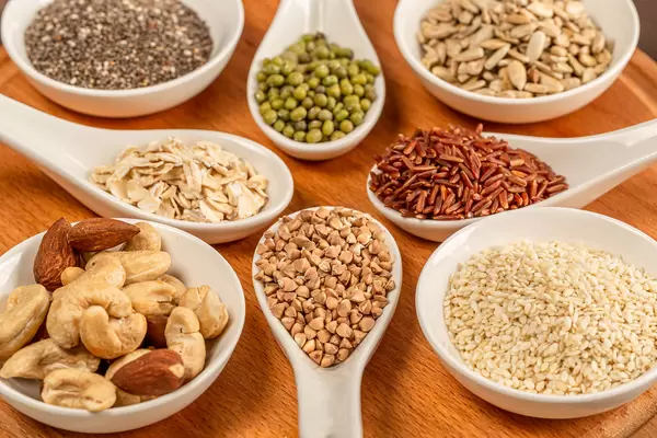 Diet cereals, seeds and nuts on a wooden background, close-up