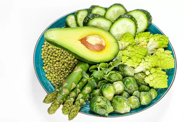 Diet food concept, green fresh vegetables and mung beans in a plate on a white background