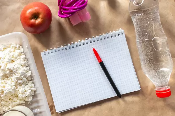 Diet planning. Meal plan. skipping rope and healthy food: a bottle of water, apple, cottage cheese (Flip 2019)