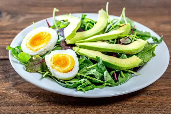 Diet salad with herbs, boiled eggs and avocado