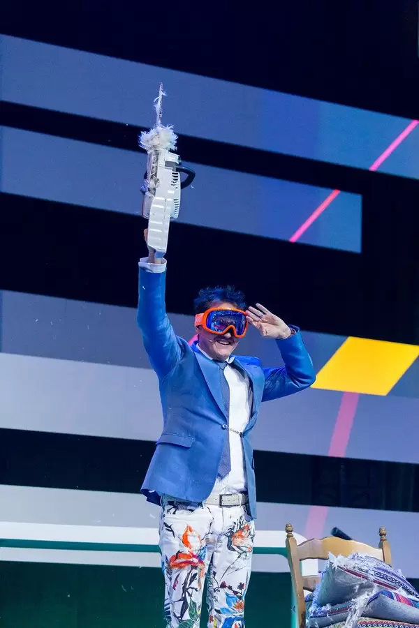 Dietmar Dahmen on stage with a saw and a colorful outfit