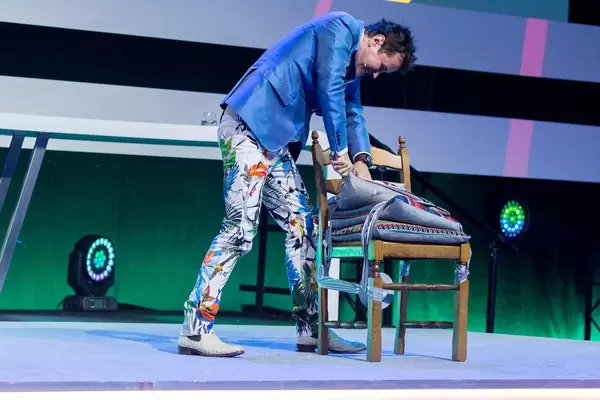 Dietmar Dahmen schneidet in ein Kissen auf der Bühne der Digital X in Köln