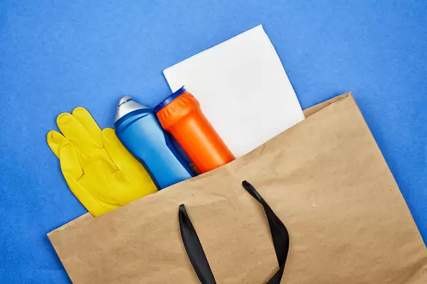 Different cleaning products in shopping bag. Buy cleaning supplies