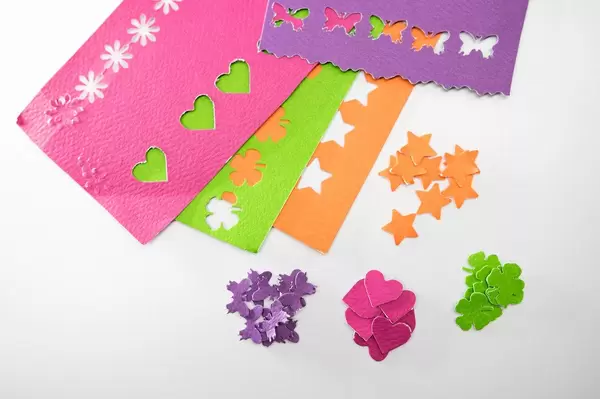 Different color paper cut outs on a white background