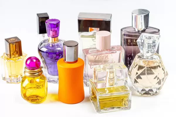 Different perfume bottles on light background (Flip 2020)