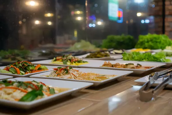 Different Salads, Stir Fried Vegetables and Raw Vegetables on Plates at a Buffet inside a Restaurant