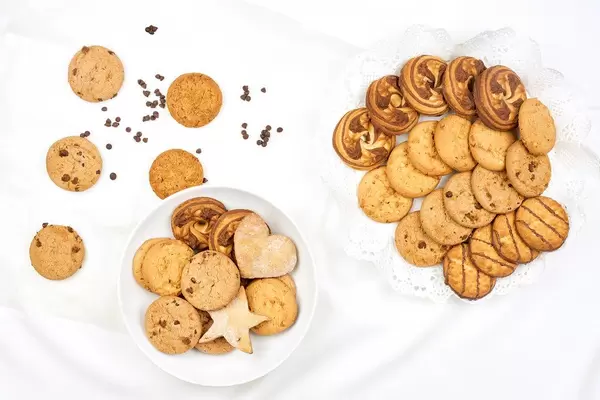 Different sweet cookies on pure white blanket