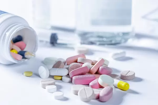 Different tablets and pills in yellow, pink and white