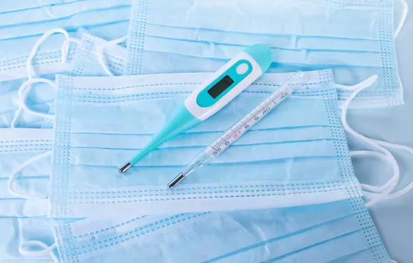 Digital and analog thermometer on a medical face masks