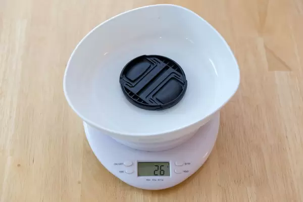 Digitale Küchenwaage und ein Objektivdeckel