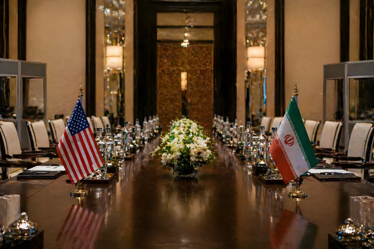 Diplomatischer Verhandlungstisch mit US- und Iran-Flaggen
