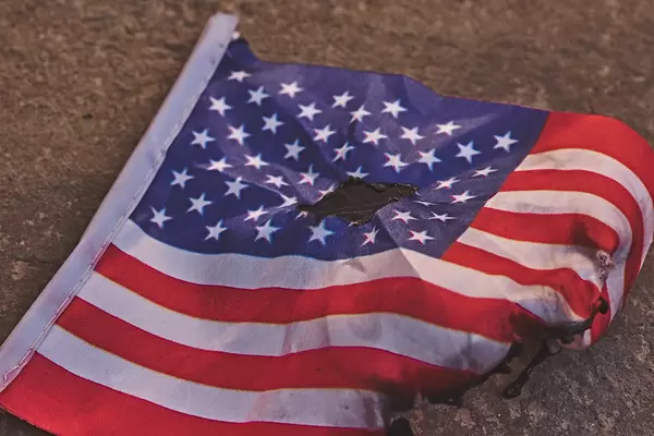 Dirty and torn american flag on the ground