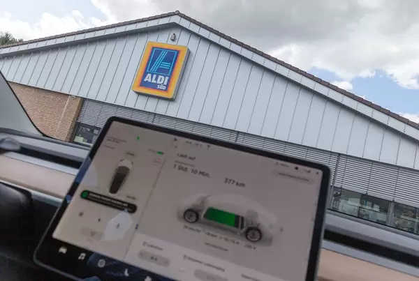 Display-Monitor im Tesla Model 3 überwacht den Ladevorgang an der Solarenergie-Ladestation auf einem Aldi-Süd Parkplatz