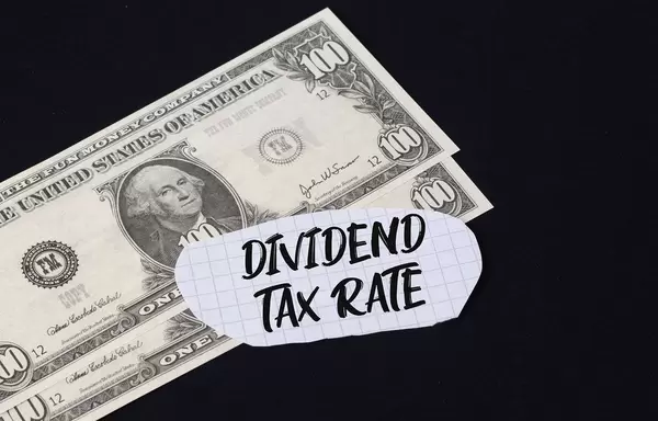 Dividend Tax Rate text and dollar banknotes