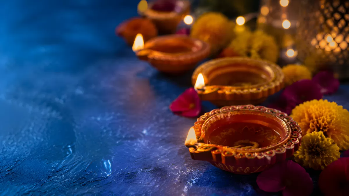 Diwali-Öllampen mit Ringelblumen auf blauem Untergrund