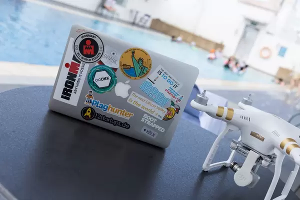 DJI Phantom 3 und MacBook bedeckt mit Reise- und Start-up-Stickern
