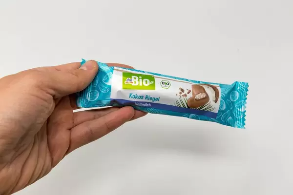 DM Bio-Vollmilch Kokosriegel in Verpackung gehalten von einer Hand