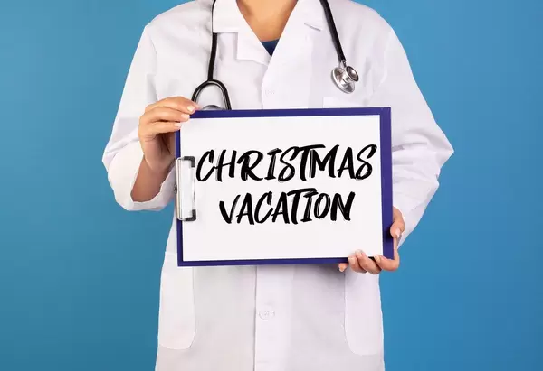 Doctor holding clipboard with Christmas Vacation text