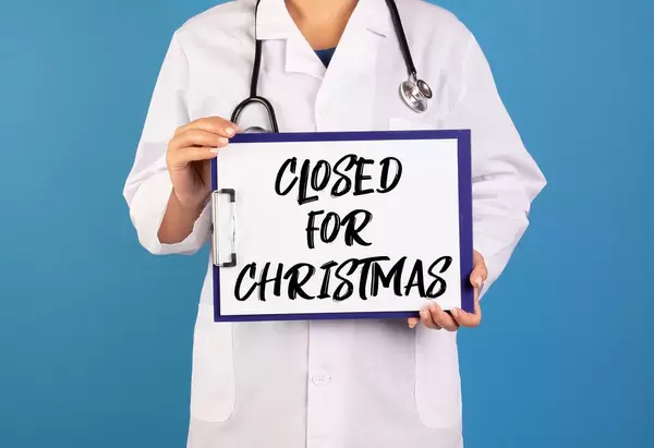Doctor holding clipboard with Closed for Christmas text