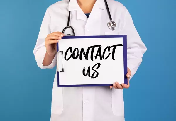 Doctor holding clipboard with Contact us text