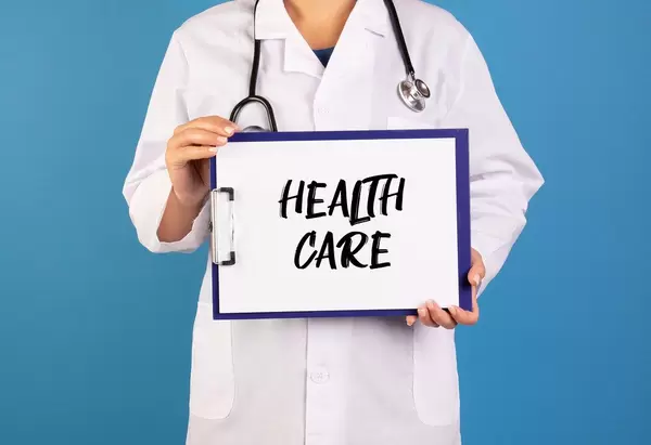 Doctor holding clipboard with Health care text