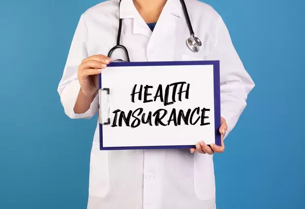 Doctor holding clipboard with Health insurance text