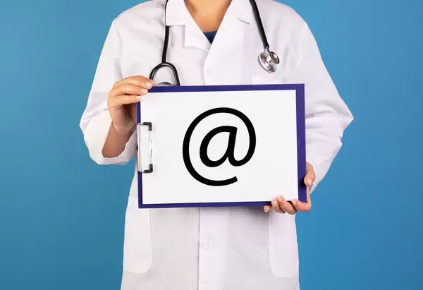 Doctor holding clipboard with @ sign