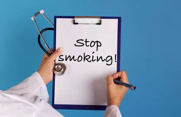 Doctor holding clipboard with Stop smoking text