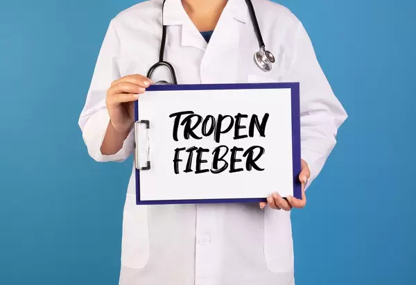 Doctor holding clipboard with Tropen Fieber text