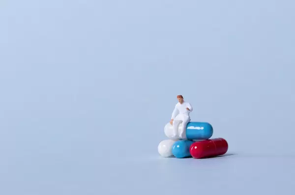 Doctor sitting on a stack of pills