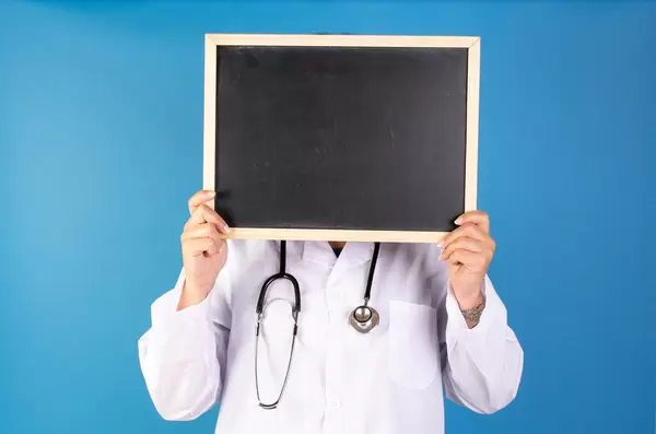 Doctor with blackboard on blue background