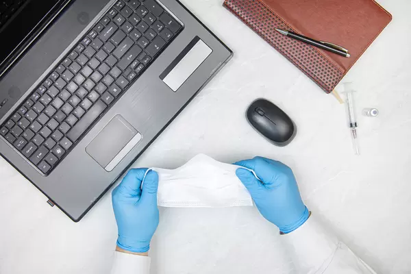 Doctor with blue gloves and face mask covid-19 pandemic concept