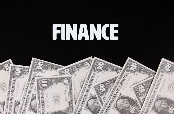 Dollar banknotes with Finance text on black background