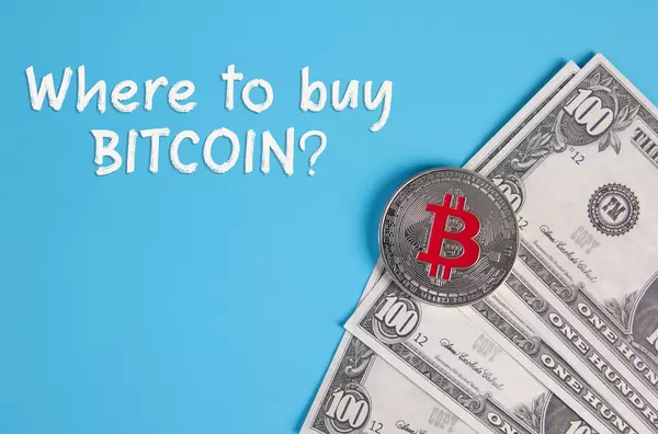 Dollar banknotes with silver Bitcoin coin and Where to buy Bitcoin text