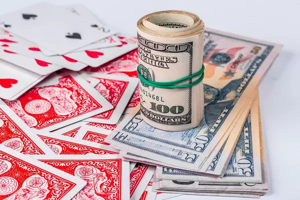Dollars and playing cards on white background