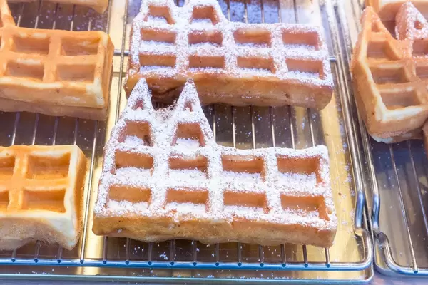 Dom Waffeln, Waffeln in Form des Kölner Doms, teilweise mit Puderzucker, auf Backrost