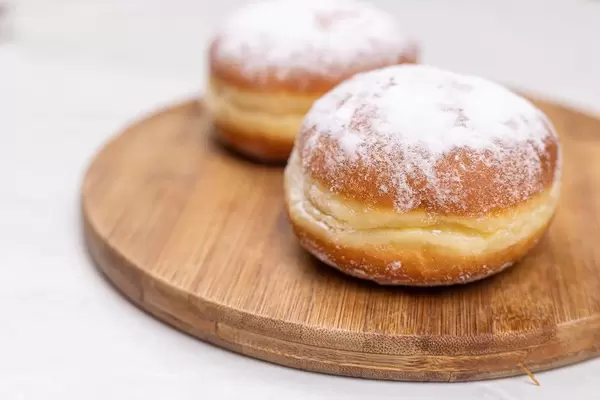Donuts with Sugar on top on the round wooden board