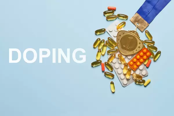 Doping for athletes - Gold medal and doping pills with capsules on a blue background