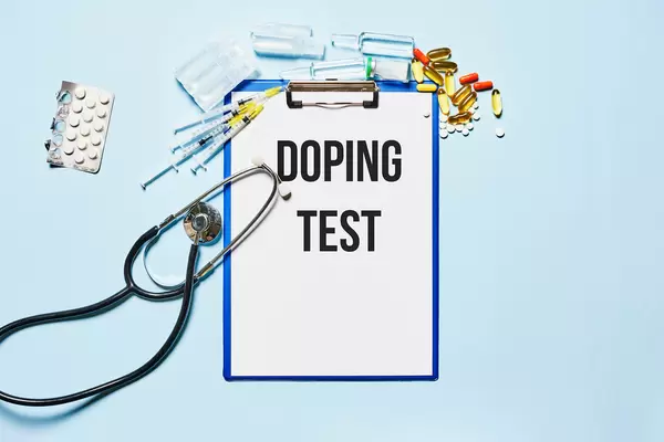 Doping test - Medical stethoscope, pills, capsules and syringes with clipboard