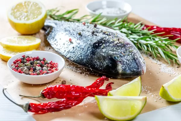 Dorado with spices, lime slices and fresh rosemary