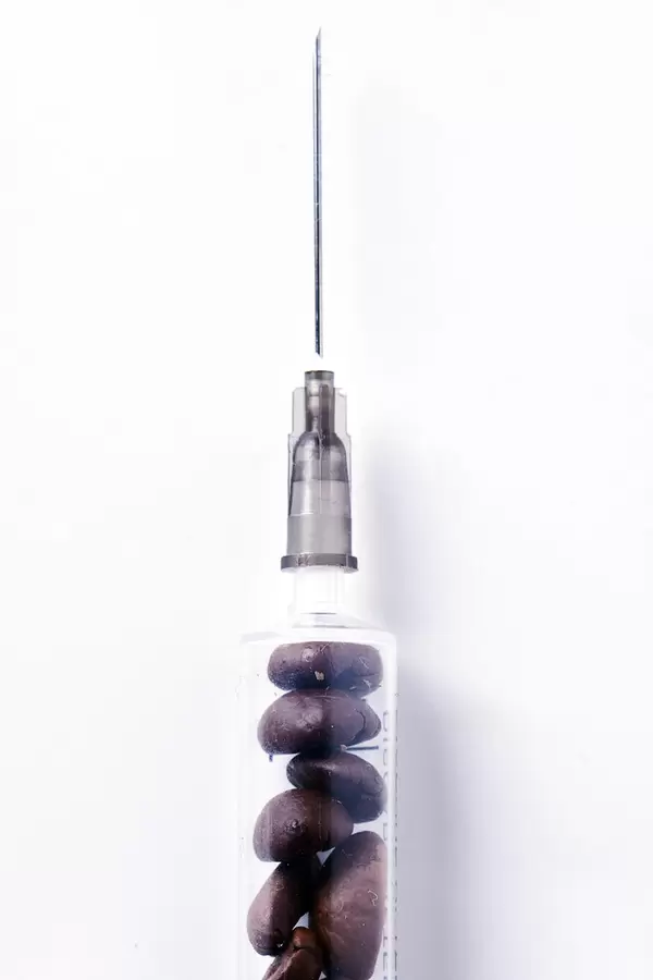 Dose of refreshing coffee - Syringe with raw coffee beans