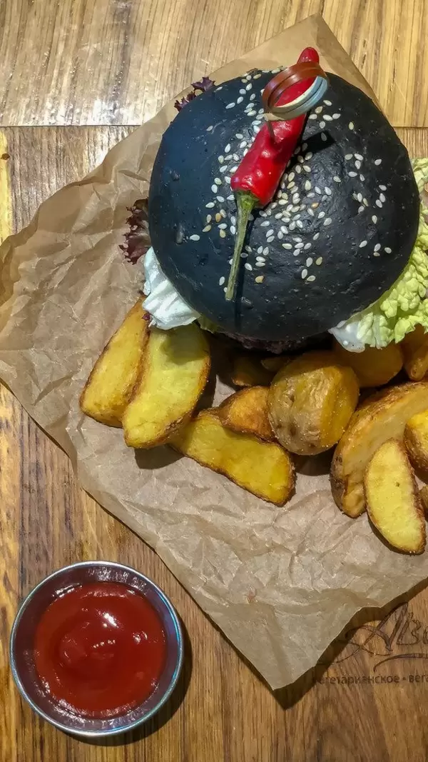 Draufsicht des Veg Kuro Burgers beim Avocado Cafe